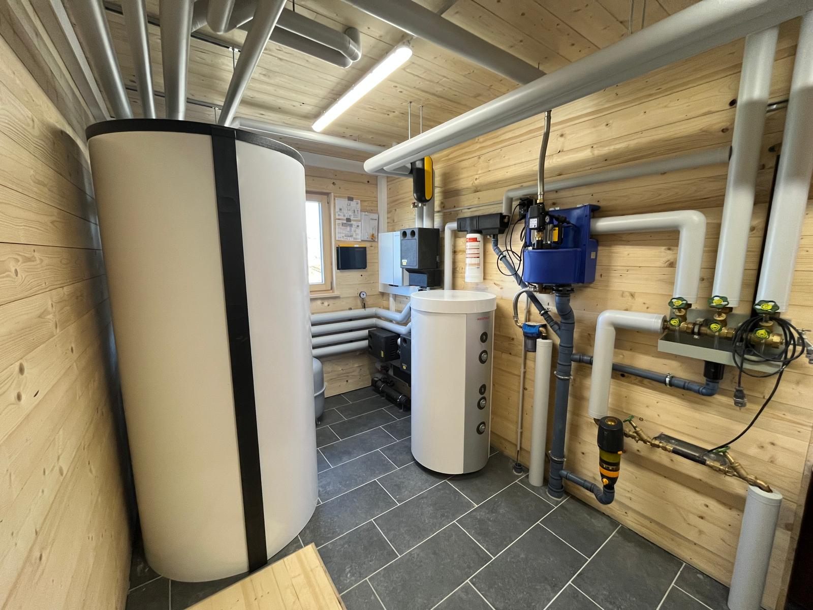 Technikraum mit Holzverkleidung, Pufferspeicher und Warmwasserspeicher